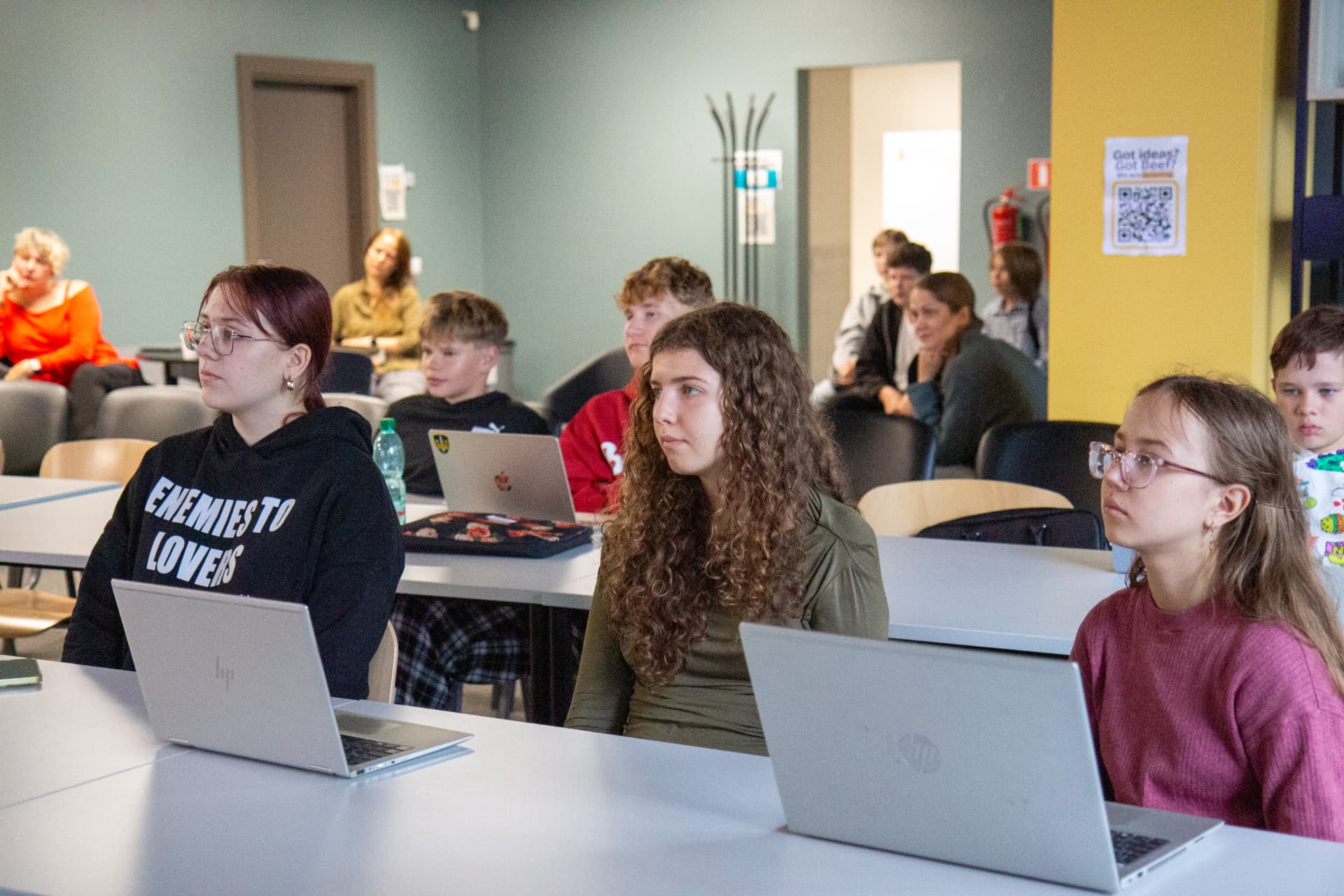 Teenagers working on laptops in an AI workshop